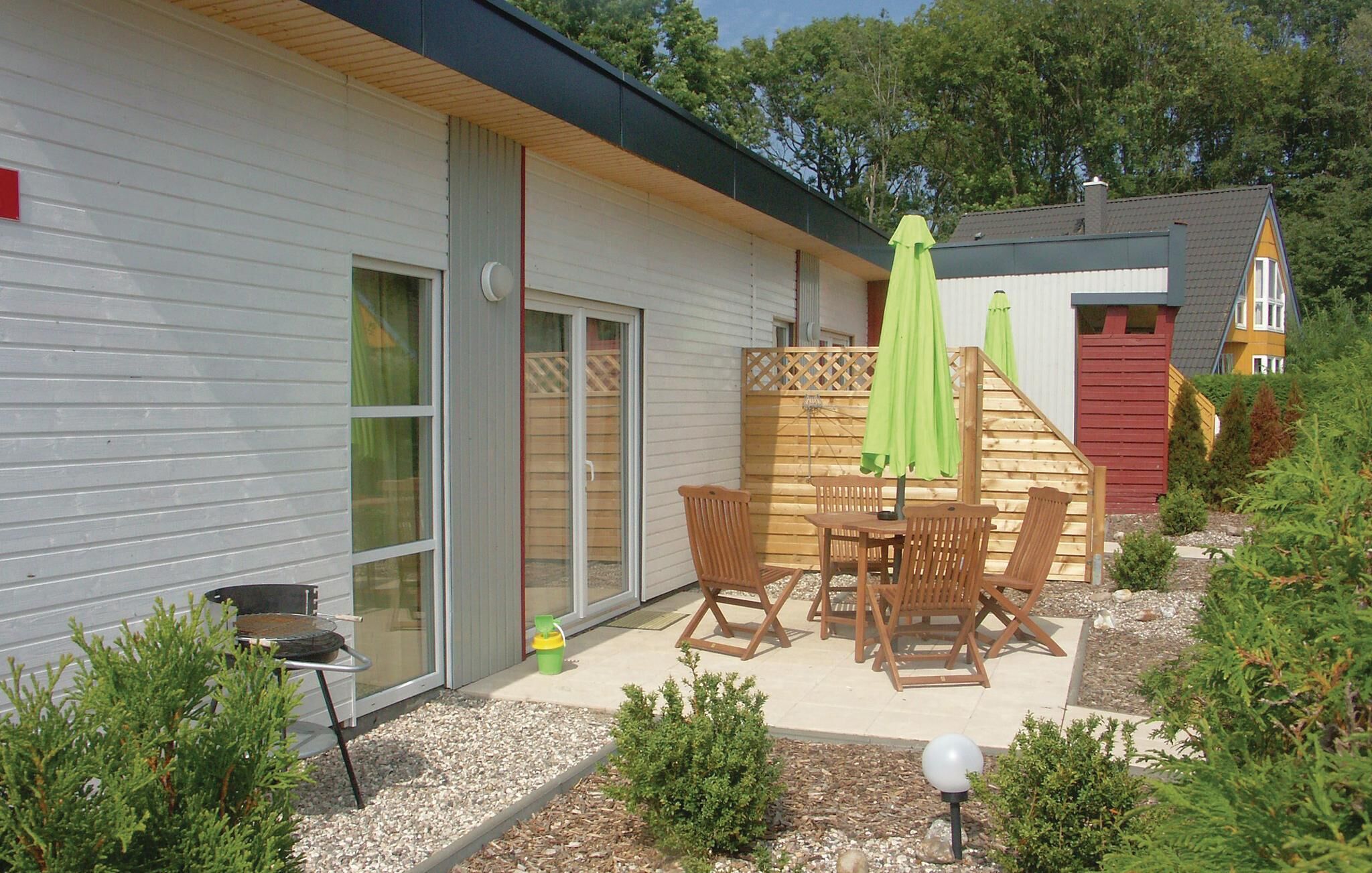 A patio with outdoor furniture, a wooden deck, and a small garden area with gravel and plants.