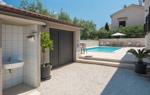 Relax by the pool surrounded by a patio with lounge chairs and a small table.