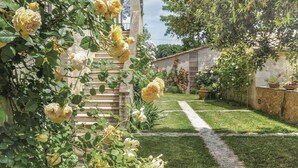 A garden with a stone staircase leading to a building, surrounded by lush greenery and yellow flowers. - Beautiful home in Poggibonsi SI (Poggibonsi SI)