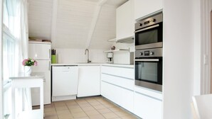 A modern kitchen with white cabinets, a dishwasher, a coffee maker, and a double oven. - Stunning home in Blåvand with sauna (Blåvand)