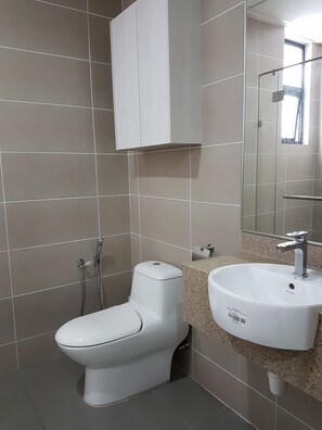 A modern bathroom with a toilet, sink, and shower.