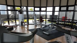A gym with treadmills, weight machines, and dumbbells. - MZ Homestay Kuala Lumpur (Kuala Lumpur)