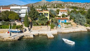 Un borgo costiero con edifici, un porto turistico e una barca.