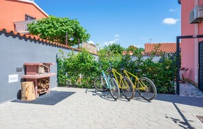 Relax in a serene courtyard surrounded by charming buildings with terracotta roofs, perfect for a leisurely bike ride or a quiet moment on a bench.