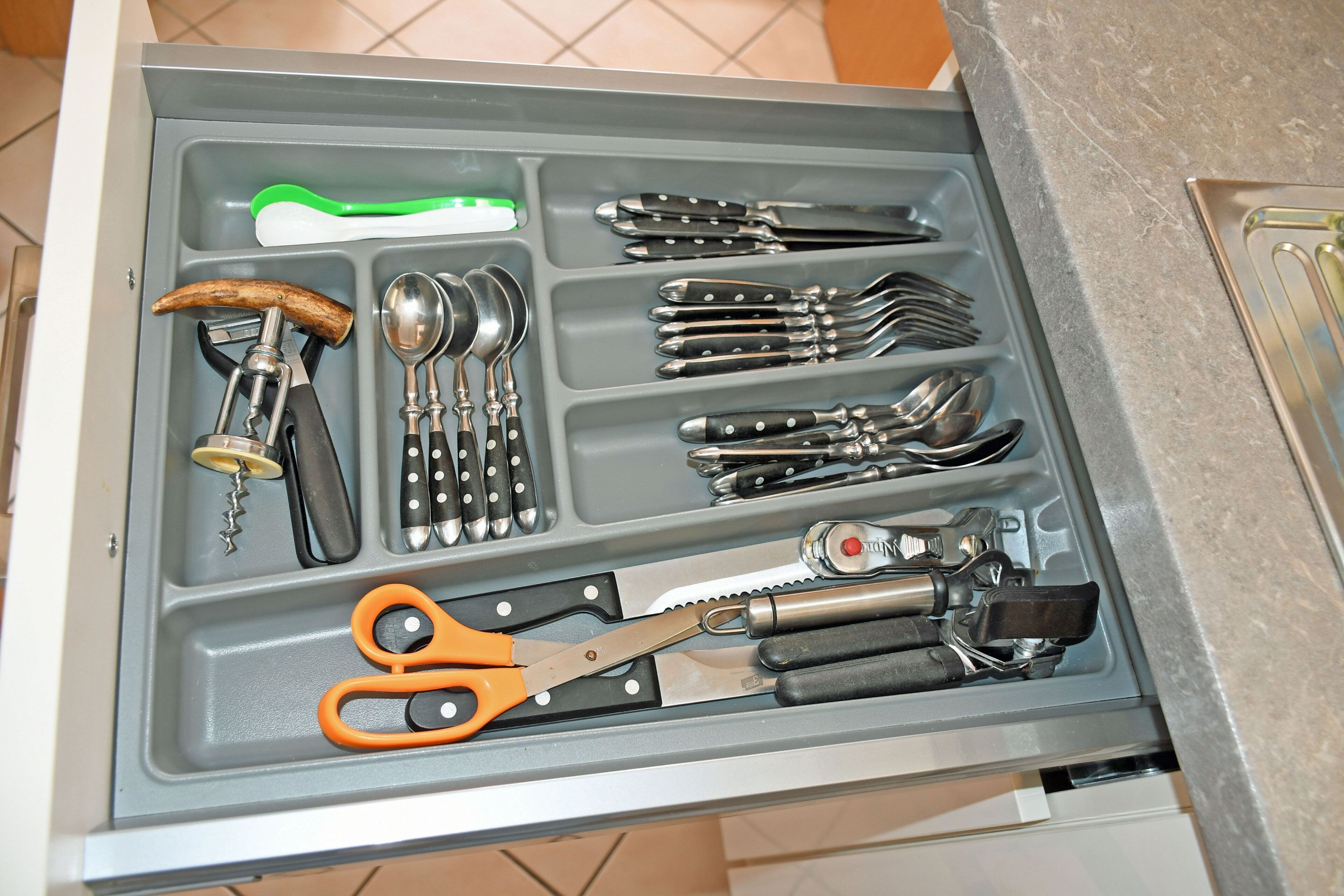 Un cajón con diferentes utensilios y herramientas de cocina.