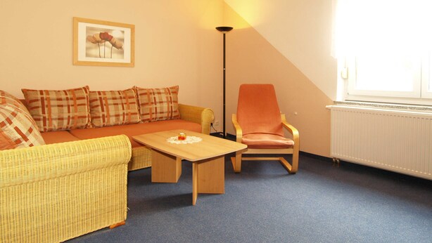 A cozy living room with a sofa, armchair, and coffee table. - Fritz-Reuter-Str. 10a. Curr. FR-10 - Fritz-Reuter-Str. 10a (Kühlungsborn)