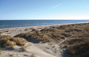 A beach with sand dunes and a clear view of the ocean.