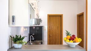 A compact kitchen with a built-in oven, a coffee maker, and a potted plant on the counter. - Beautiful home in Kastel Sucurac (Kastel Sucurac)