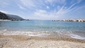 A pebble beach with clear water and rocky outcrops. - 3 bedroom beautiful home in Scilla (RC) (Scilla (RC))