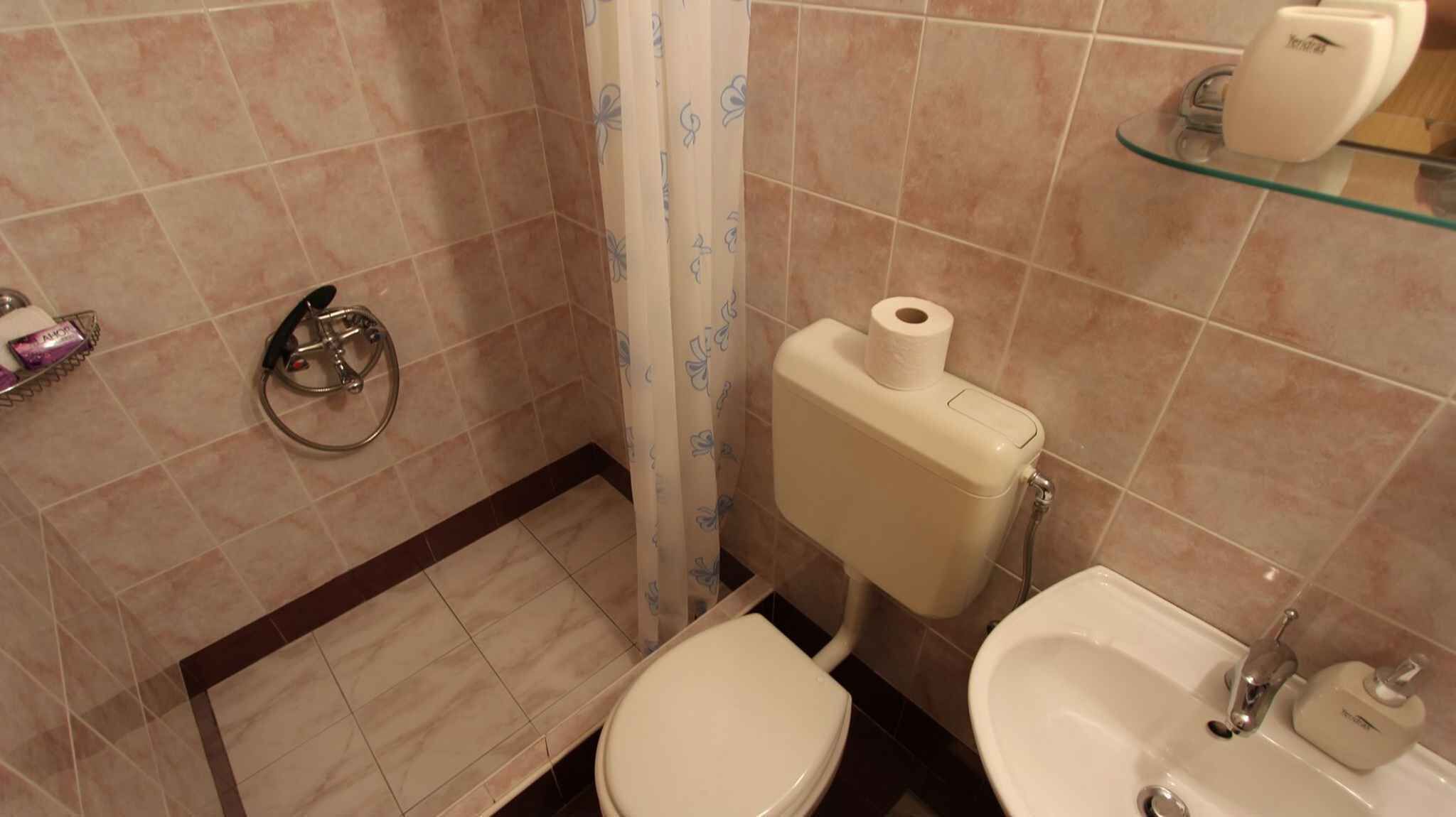 A bathroom with a toilet, bidet, and sink.