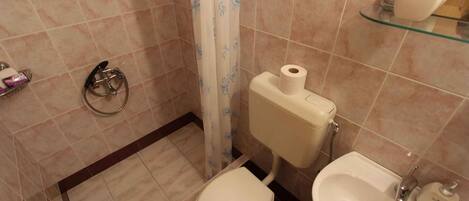 A bathroom with a toilet, bidet, and sink.
