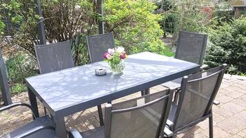 An outdoor patio with a rectangular table and four chairs.