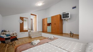 A hotel room with a bed, a TV, a wardrobe, and a desk with a chair. - Amazing apartment in Porec with WiFi (Porec)