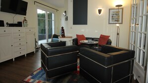 A living room with a sofa set, a television, a cabinet, and a window. - 5 Kontor - Holiday home Alte Molkerei (Rankwitz)