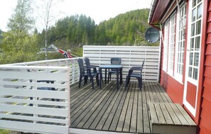 A wooden deck with a white fence, a table, and four chairs. - Nice home in Hovsherad with house sea view (Hovsherad)