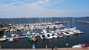Ein Yachthafen mit zahlreichen Booten, ein klarer Himmel und eine entfernte Küstenlinie.