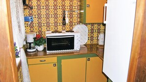 Een kleine keuken met een magnetron, een koffiezetapparaat en een kleine potplant.