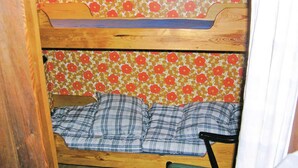 Een stapelbed met een bloemen behang en een geruit dekbed.