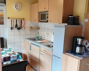 Kjøleskap, mikrobølgeovn og høy barnestol