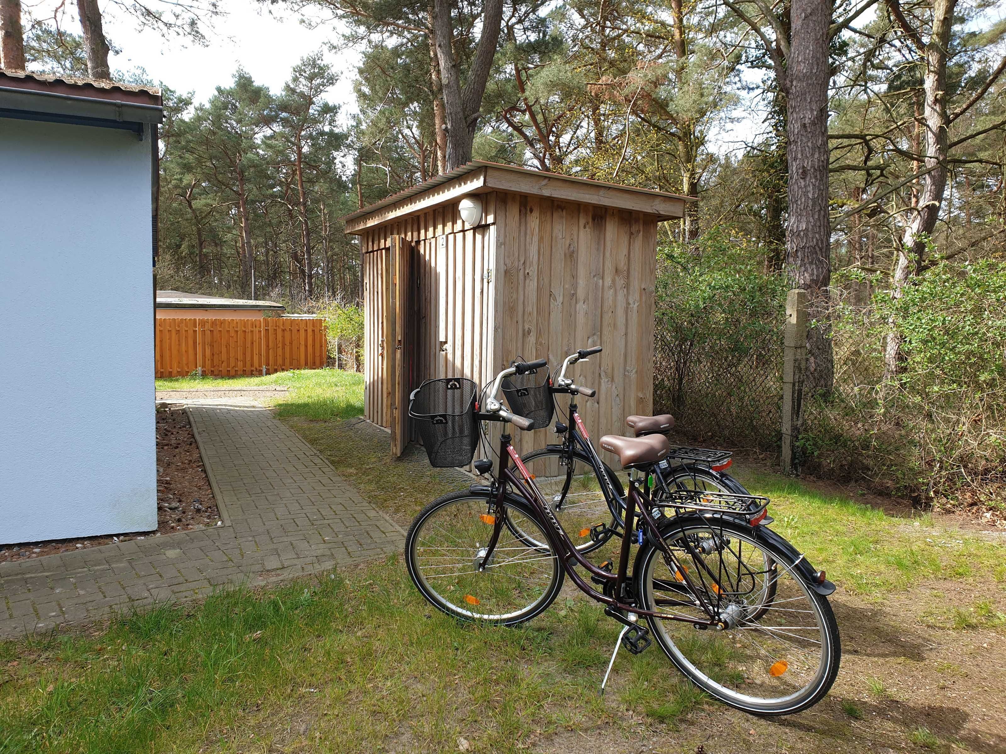 Ein Holzschuppen mit einem Fahrrad davor.