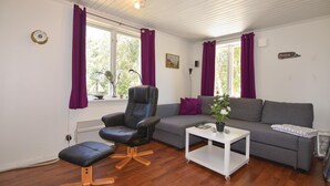A cozy living room with a leather chair, grey sofa, and a small white table. - Awesome home in Hunnebostrand (Hunnebostrand)