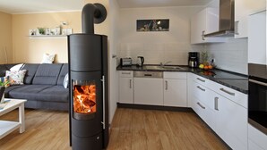 Een moderne keuken met witte kasten, een zwarte kookplaat en een houten vloer.