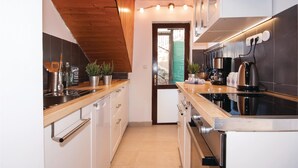 Una cocina moderna con techo de madera, electrodomésticos de acero inoxidable y vistas al exterior.