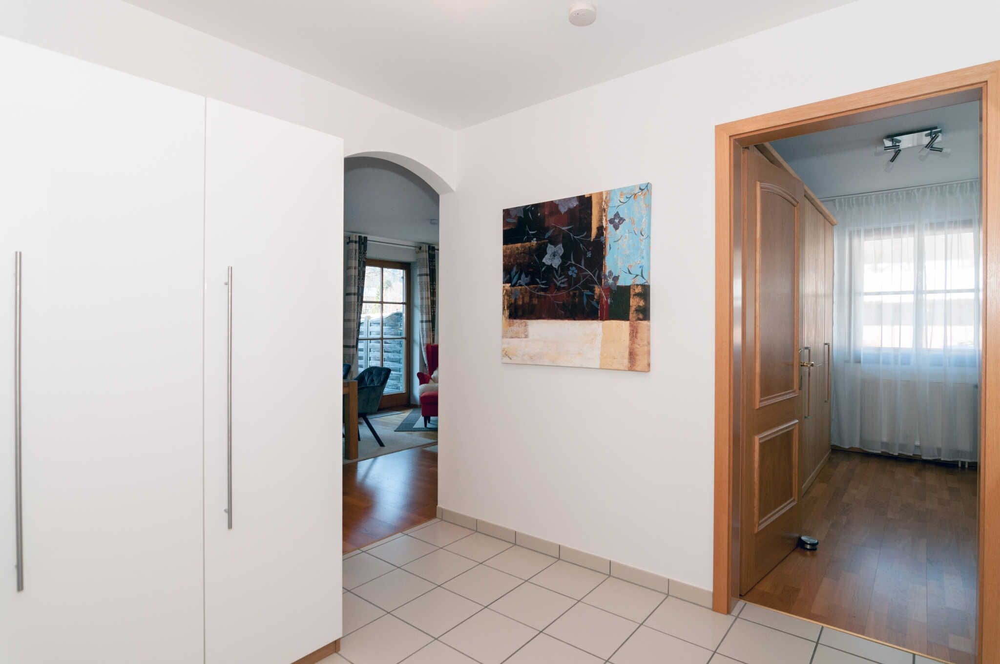 A hallway with a white door, a painting, and a wooden door leading to another room.