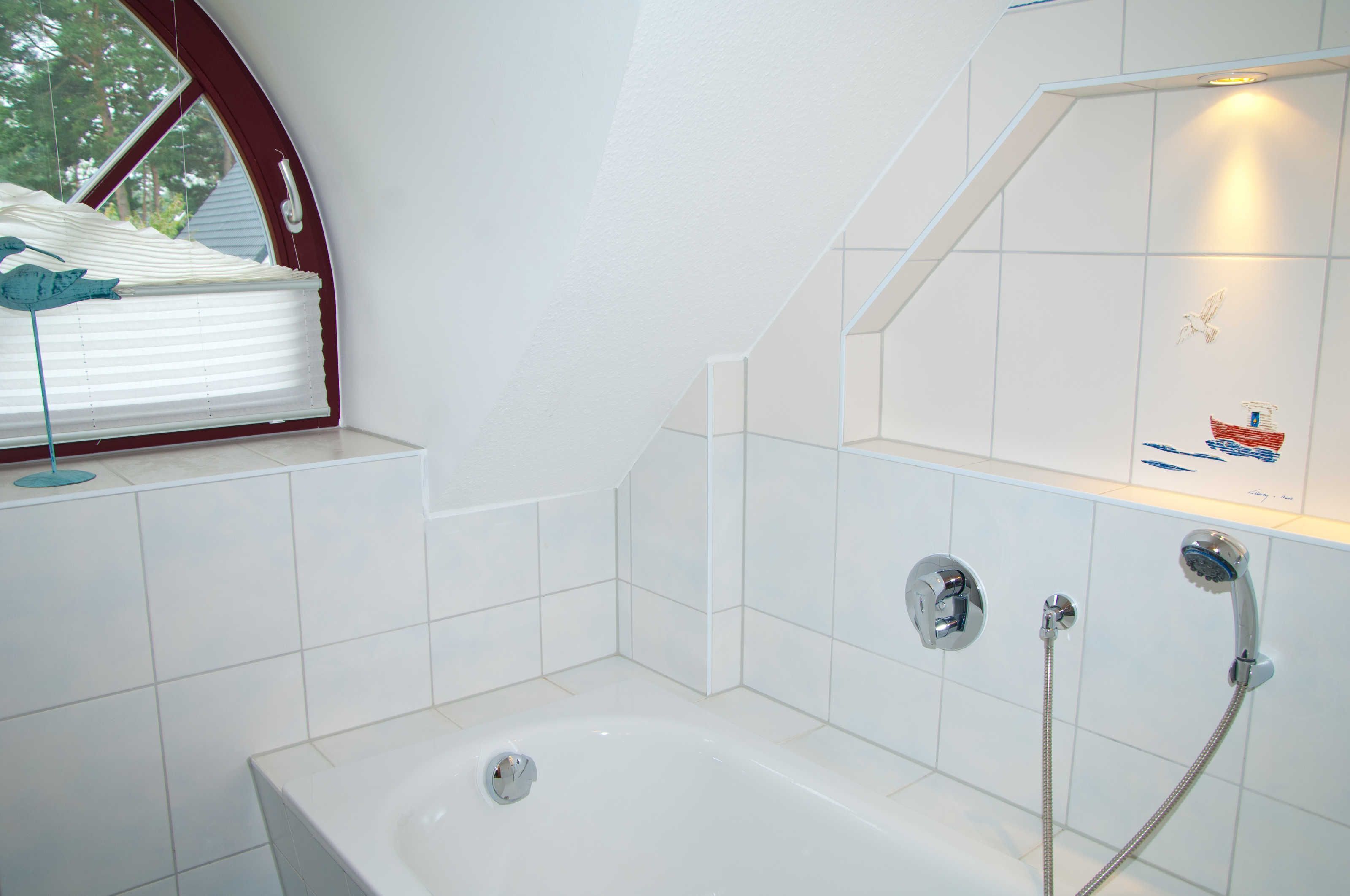 A modern bathroom with a bathtub, a shower, and a window with blinds.