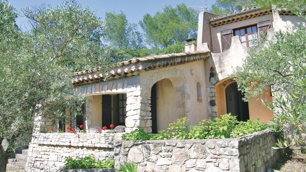 A stone house with a tiled roof, arched doorways, and a stone staircase leading to a porch with red flowers. - Cozy home in Draguignan (Draguignan)