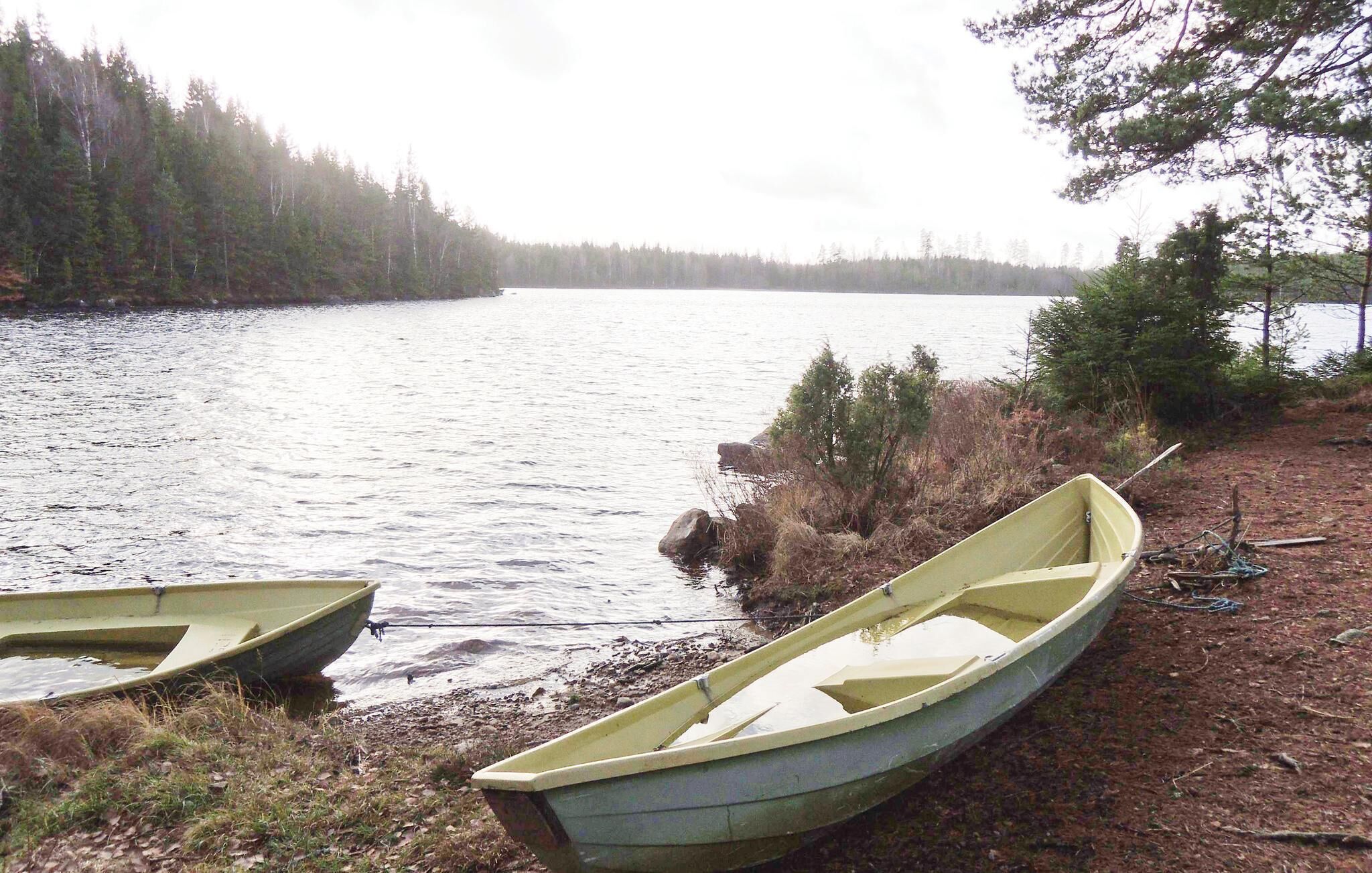 Two boats on a calm lake with a forested shoreline.