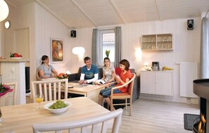 Relax in a warm and inviting space with a fireplace, comfortable seating, and a dining area.