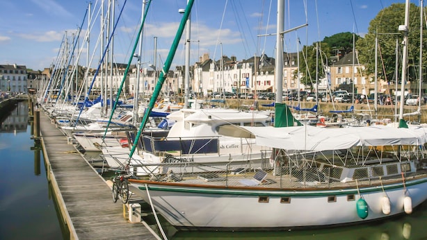 A marina with multiple boats docked in calm waters, a wooden dock, and buildings in the background. - Lovely home in Cadouarn with WiFi (Cadouarn)