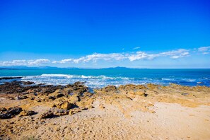 A rocky beach with clear blue water and distant mountains. - 44263 Romantic Sa Nau - 44263 Romantic vacation home Sa Nau (Colonia de Sant Pere)