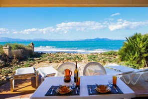 A table set for two with a view of the sea and mountains.