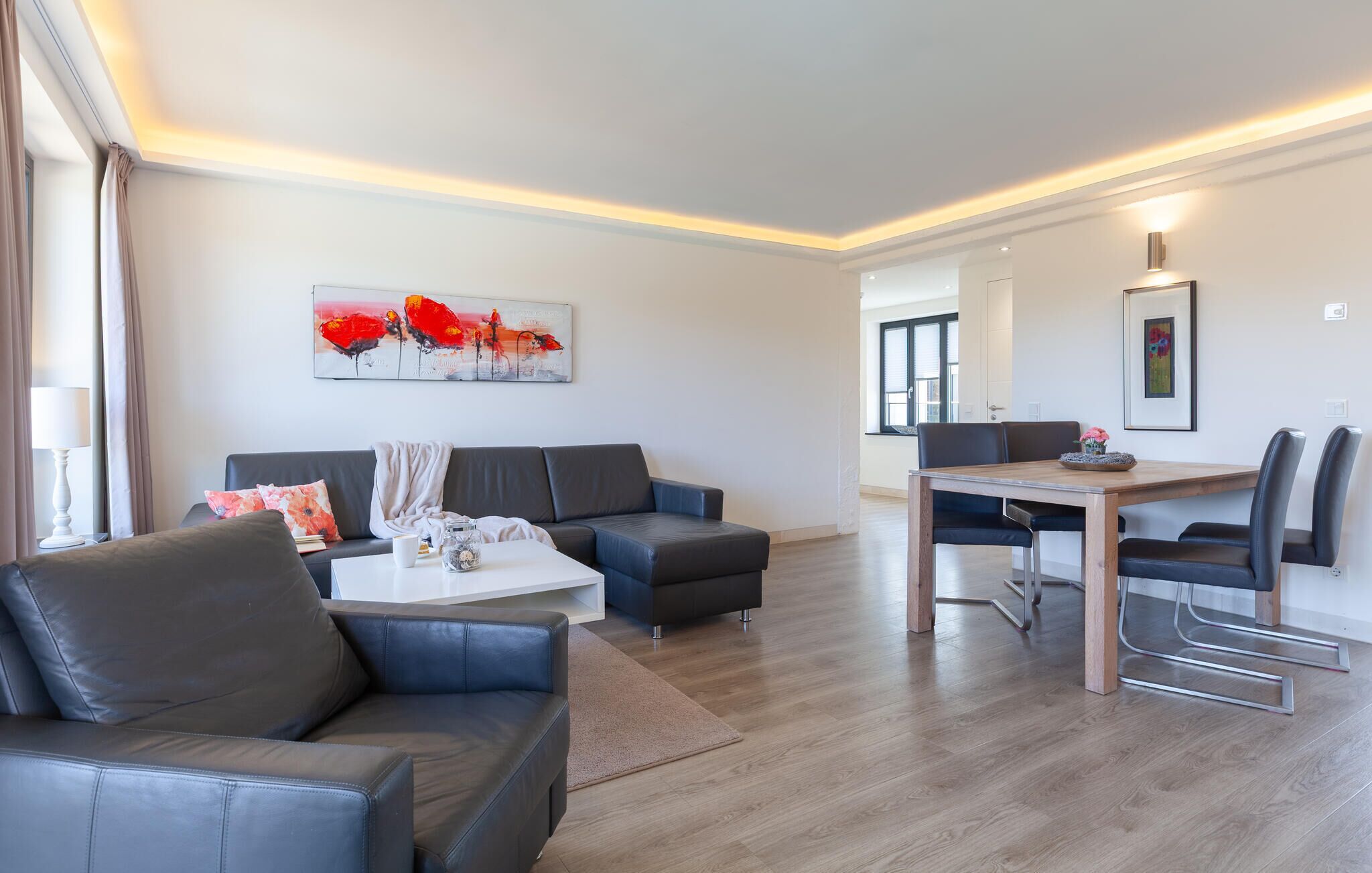Una sala de estar moderna con un sofá, una mesa de centro y una mesa de comedor.