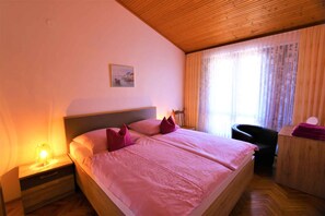 Cozy retreat with a large bed, wooden headboard, and a bedside table with a lamp.