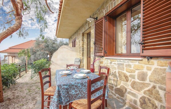 An outdoor dining area with a table set for two, stone walls, wooden shutters, and a view of the surrounding landscape. - Stunning home in S. M. di Castellabate with WiFi (S. M. di Castellabate)