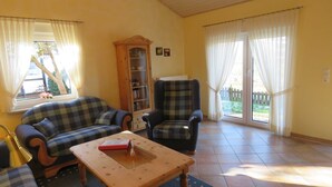 Un salón con sofá, sillón y una mesa de centro de madera.