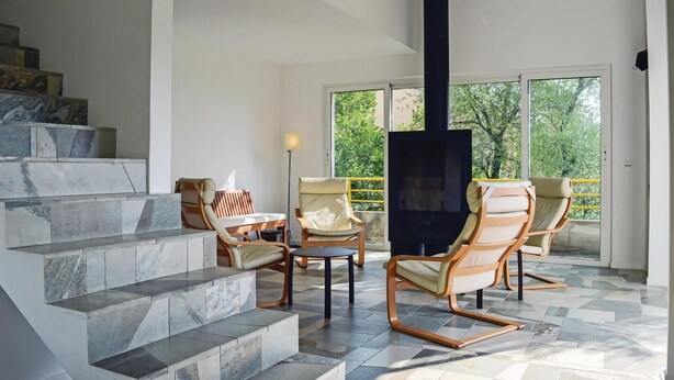 A modern living area with a stone staircase, comfortable seating, and a large TV. - Cozy home in San Giuliano with WiFi (San Giuliano)
