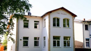 Un bâtiment à deux étages, doté d’une façade blanche et d’un toit brun. Le bâtiment possède de nombreuses fenêtres et une enseigne sur laquelle on peut lire « Villa Waldwick ».