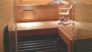 A sauna with wooden benches, a wooden bucket, and towels. - Refugium Strandallee - Refugium Strandallee, 91 m², 2 - 4 persons (Neustadt in Holstein)