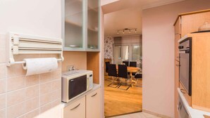A compact kitchen with a microwave, a small oven, and a wooden cabinet.