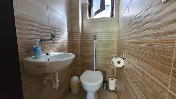 A bathroom with a sink, toilet, and bidet.