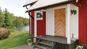A red and white building with a wooden door and a small porch. - 2 bedroom beautiful home in åsensbruk (Åsensbruk)