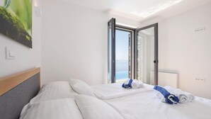 Una habitación de hotel con dos camas, un ventanal con vistas y un cuadro en la pared.