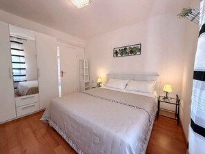 A bedroom with a bed, bedside tables, a wardrobe, a ladder, and a wall-mounted picture. - Holiday apartment with shared pool and barbecue (Šilo)