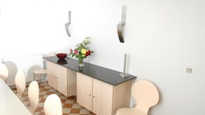 Een moderne keuken met een zwart aanrecht, houten kastjes en een rode kom op het aanrecht.