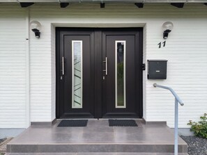 A double door with a small window, a mailbox, and a number '11' on the wall. - Spies: Holiday apartment for 2 in the middle of the green inland - Holiday apartment (Sieverstedt)