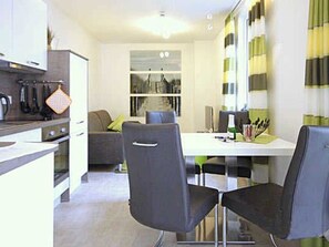 Une cuisine moderne avec un coin repas, comprenant une table et des chaises.